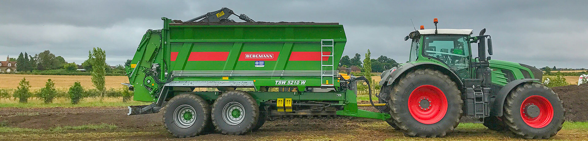 muck spreader being loaded by 360